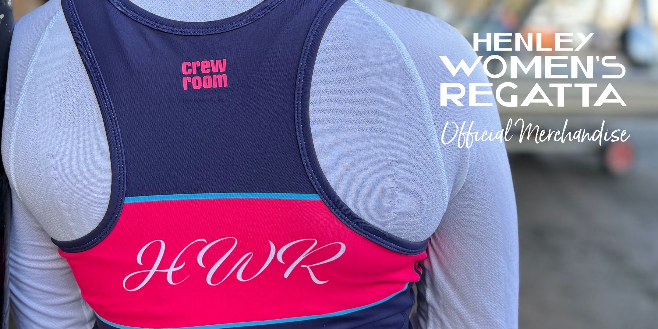 Person wearing a pink and navy vest with 'crew room' branding, featuring 'HENLEY WOMEN'S REGATTA' text.